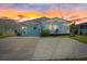 Charming coastal-style home with a front porch and a spacious driveway, featuring sunset at 4400 Floramar Ter, New Port Richey, FL 34652