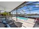Enclosed lanai features a plunge pool, waterfront views, lounge chairs, and an outdoor dining set at 4400 Floramar Ter, New Port Richey, FL 34652