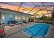 Screened-in lanai features a plunge pool with a colorful sunset at 4400 Floramar Ter, New Port Richey, FL 34652