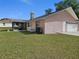Exterior view of home featuring a screened in patio, fenced in backyard, and stone chimney at 4503 Sheffield Rd, Land O Lakes, FL 34639