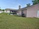 A view of the house's exterior and chimney stack overlooking the spacious backyard with a screened-in patio, perfect for outdoor enjoyment at 4503 Sheffield Rd, Land O Lakes, FL 34639