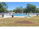 Community pool area with sun loungers, umbrellas, and table seating at 4503 Sheffield Rd, Land O Lakes, FL 34639