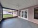 Covered screened-in patio area with ceiling fan, and access doors leading to a fenced in backyard at 4503 Sheffield Rd, Land O Lakes, FL 34639