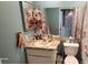 Functional bathroom with a standard toilet, sink, vanity, mirror, and some toiletries, ready for everyday use at 4548 Somerset Pl, New Port Richey, FL 34652