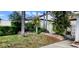 Home's exterior with healthy lawn, mature trees, and an attractive wrought iron gate to the entrance at 4548 Somerset Pl, New Port Richey, FL 34652