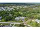 A high aerial view of the property, showcasing the main house, separate garage, pool, and lush surrounding landscape at 4573 Ontario Dr, New Port Richey, FL 34652