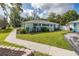 Beautiful single-story home with well-kept lawn, a tidy garden bed, and a paved walkway along the side at 4573 Ontario Dr, New Port Richey, FL 34652
