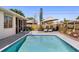 Inviting backyard pool with a sun deck, lounge chairs, umbrella, and well-maintained landscaping at 4731 Egret Rd, Venice, FL 34293