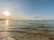 Calm beach with the sun rising over the water, showing glistening waves and clear skies at 4945 Getner St, New Port Richey, FL 34652
