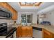 Bright kitchen features stainless steel appliances, granite countertops, and a window overlooking the pool at 512 Winding Willow Dr, Palm Harbor, FL 34683
