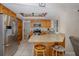 Open kitchen boasts a breakfast bar, stainless steel refrigerator and lighting at 512 Winding Willow Dr, Palm Harbor, FL 34683