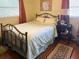 Cozy bedroom with decorative iron bed frame, wood floors, and bedside table at 5406 Dartmouth Rd, New Port Richey, FL 34652