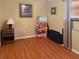 Modest bedroom with wood floors, neutral walls, and storage of paper products at 5406 Dartmouth Rd, New Port Richey, FL 34652