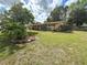 Landscaped front yard with mature tree, showcasing the exterior of this inviting single-story home at 5406 Dartmouth Rd, New Port Richey, FL 34652