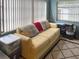 Casual living room with a comfortable yellow couch, large window, and patterned rug at 5406 Dartmouth Rd, New Port Richey, FL 34652
