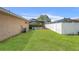 Large backyard with fence, trees, and a screened pool enclosure at 5411 Wellfield Rd, New Port Richey, FL 34655