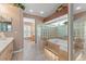 Bright bathroom featuring a tiled platform tub encased in glass blocks, offering a luxurious spa-like experience at 5411 Wellfield Rd, New Port Richey, FL 34655