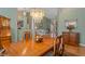 Open-concept dining area featuring a fruit-laden wooden table with views into a connected living space at 5411 Wellfield Rd, New Port Richey, FL 34655