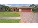 Charming home featuring a well-manicured lawn, brick-paved driveway, and a two-car garage at 5411 Wellfield Rd, New Port Richey, FL 34655