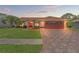 Beautiful home at twilight with lush lawn, brick driveway, and well-maintained landscaping at 5411 Wellfield Rd, New Port Richey, FL 34655