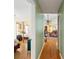 Hallway view showcasing hardwood floors, with glimpses into a bedroom and living room that features ceiling fan and vaulted ceiling at 5411 Wellfield Rd, New Port Richey, FL 34655