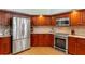 Spacious kitchen featuring stainless steel appliances and wood cabinetry at 5411 Wellfield Rd, New Port Richey, FL 34655