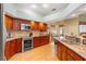 Well-equipped kitchen boasts stainless steel appliances, granite countertops, and warm wood cabinetry at 5411 Wellfield Rd, New Port Richey, FL 34655
