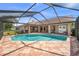 A sparkling pool is surrounded by a screened enclosure and brick patio at 5411 Wellfield Rd, New Port Richey, FL 34655
