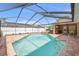 Inviting screened-in pool area with brick paver deck, perfect for outdoor entertaining at 5411 Wellfield Rd, New Port Richey, FL 34655