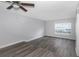 Bright bedroom featuring wood-look flooring, a ceiling fan, and a large window at 5651 Townhouse Dr # 5651, New Port Richey, FL 34652