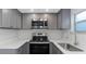 Updated kitchen with stainless steel appliances, gray cabinets, and quartz countertops at 5651 Townhouse Dr # 5651, New Port Richey, FL 34652