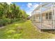 Spacious backyard featuring a screened-in patio along the back of the house at 5676 Legend Hills Ln, Spring Hill, FL 34609