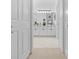 Hallway view to a bathroom with double vanity and ample lighting at 5676 Legend Hills Ln, Spring Hill, FL 34609