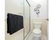 Toilet and shower with sliding door, complemented by decorative metal flower art on the wall at 5676 Legend Hills Ln, Spring Hill, FL 34609