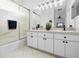 Bright bathroom featuring a double sink vanity with black hardware and a shower with glass doors at 5676 Legend Hills Ln, Spring Hill, FL 34609