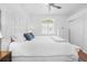 Bright primary bedroom features a white bed and neutral decor at 5676 Legend Hills Ln, Spring Hill, FL 34609