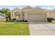 Charming single-story home with a manicured lawn, two-car garage, and well-maintained landscaping at 5676 Legend Hills Ln, Spring Hill, FL 34609