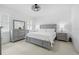 Bright main bedroom featuring a gray furniture set, carpet, and a ceiling fan at 5676 Legend Hills Ln, Spring Hill, FL 34609