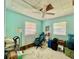 Small bedroom with light green walls features a ceiling fan, a lamp, and a sitting chair at 6045 Colony Cir, Weeki Wachee, FL 34607