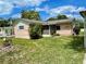 View of the front of the home with manicured lawn and garden at 6045 Colony Cir, Weeki Wachee, FL 34607