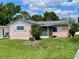 Charming pink single-story home featuring a screened porch and well-maintained lawn at 6045 Colony Cir, Weeki Wachee, FL 34607