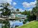Beautiful view of canal homes with well-maintained docks and lush greenery, all under a cloudy blue sky at 6045 Colony Cir, Weeki Wachee, FL 34607