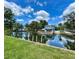 Canal-front home featuring a tiki hut style boathouse, boat ramp and lush green surroundings at 6045 Colony Cir, Weeki Wachee, FL 34607