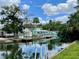 Beautiful waterfront view of canal-side homes with docks, lush greenery and blue skies with clouds at 6045 Colony Cir, Weeki Wachee, FL 34607