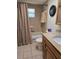 Neutral-toned bathroom featuring a shower-tub combo, toilet, vanity with stone countertop, and a classic wall mirror at 6516 Hillview Rd, Spring Hill, FL 34606