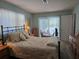Bright bedroom with view to screened pool area; complete with an iron bed frame and wooden furniture at 6516 Hillview Rd, Spring Hill, FL 34606