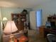 Spare bedroom furnished with wooden desk, bookcase and chair, as well as a comfortable lounge chair at 6516 Hillview Rd, Spring Hill, FL 34606