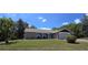 Single-story home boasts a brick facade, attached garage, and a well-manicured lawn with mature trees at 6516 Hillview Rd, Spring Hill, FL 34606