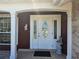 Close up of front door showing a brick facade, well-kept lawn, and a covered entrance way at 6516 Hillview Rd, Spring Hill, FL 34606