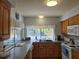 Bright kitchen with white appliances, wood cabinets, granite countertops, and a window overlooking the pool at 6516 Hillview Rd, Spring Hill, FL 34606